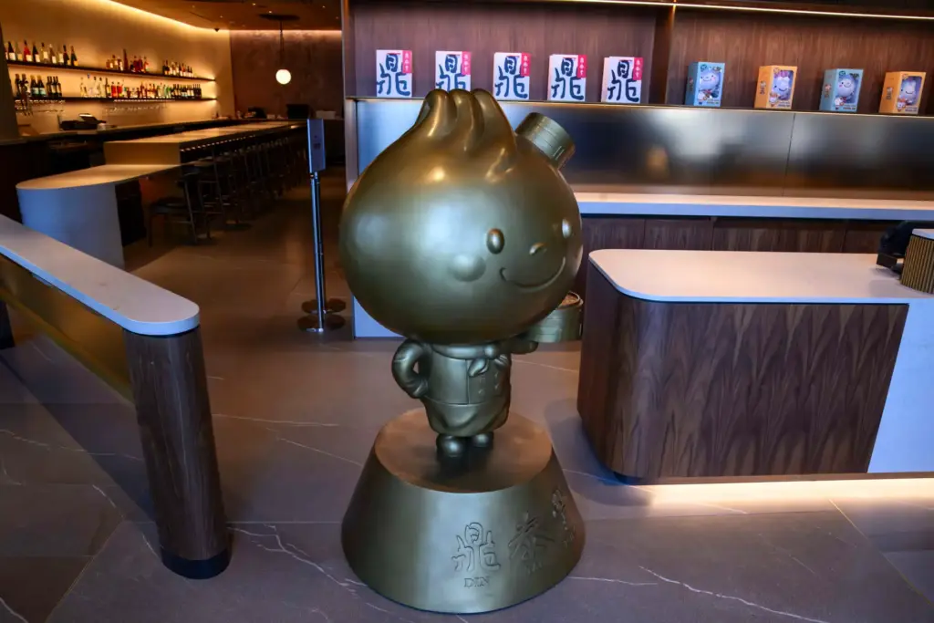 The Din Tai Fung mascot, Bao Bao, welcomes guests in...