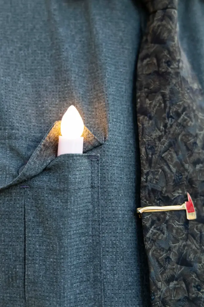 Joe Almazan tucks a lit candlestick into his shirt pocket...