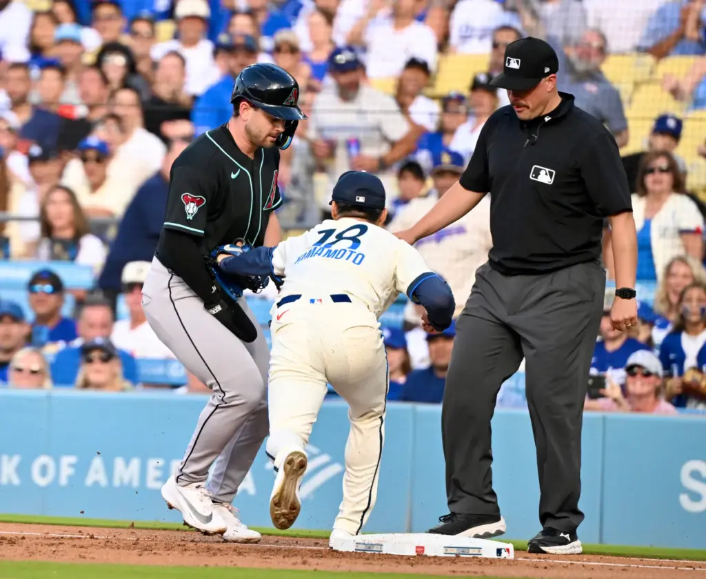 Starting pitcher Yoshinobu Yamamoto of the Dodgers tags out Tim...