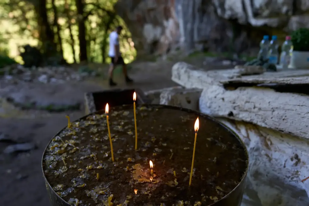 Candles burn outside a chapel at the Holy Cave of...
