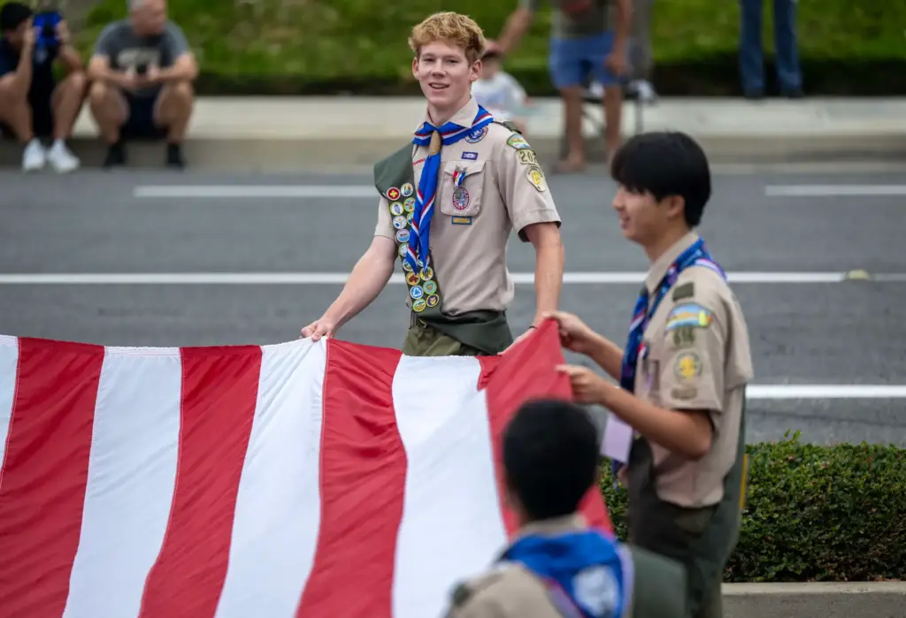Members of Boy Scouts of America Troop 2020 carry a...
