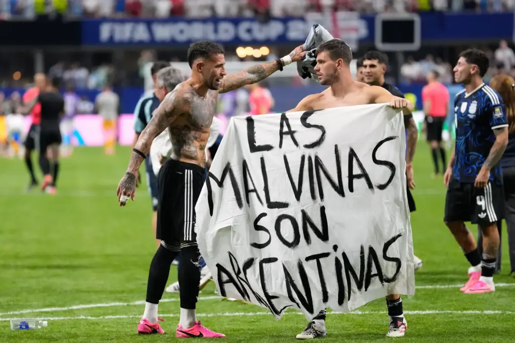 Argentina's Giovani Lo Celso holds a banner with the words 