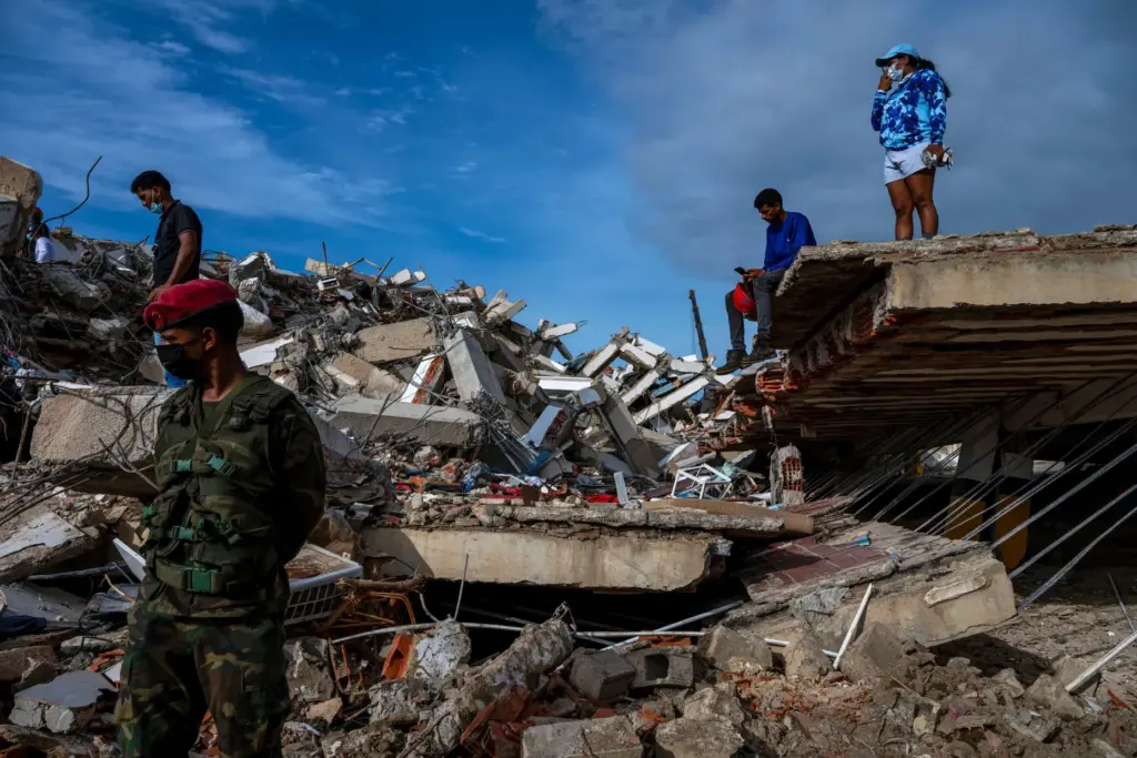 Volunteers and rescuers help to find survivors in a collapsed...