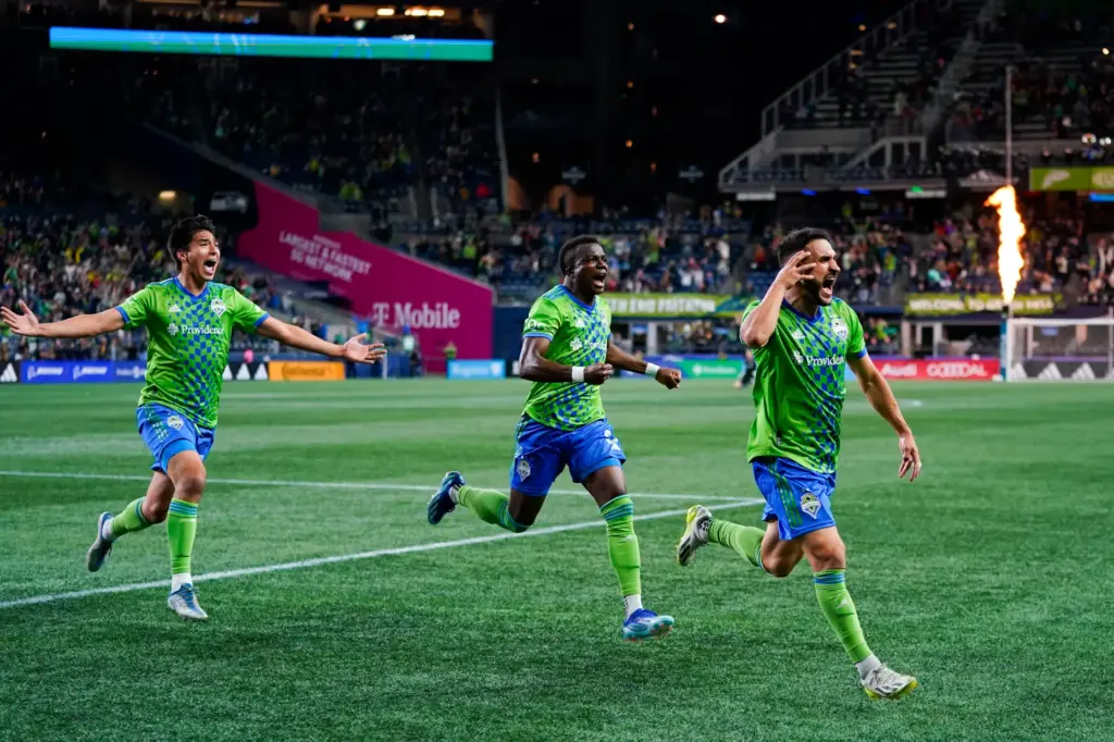 Seattle Sounders midfielder Cristian Roldan, right, celebrates his stoppage-time goal...