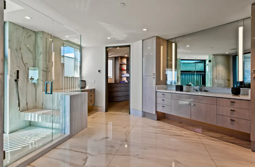 A spacious primary bathroom with custom finishes sits adjacent to...