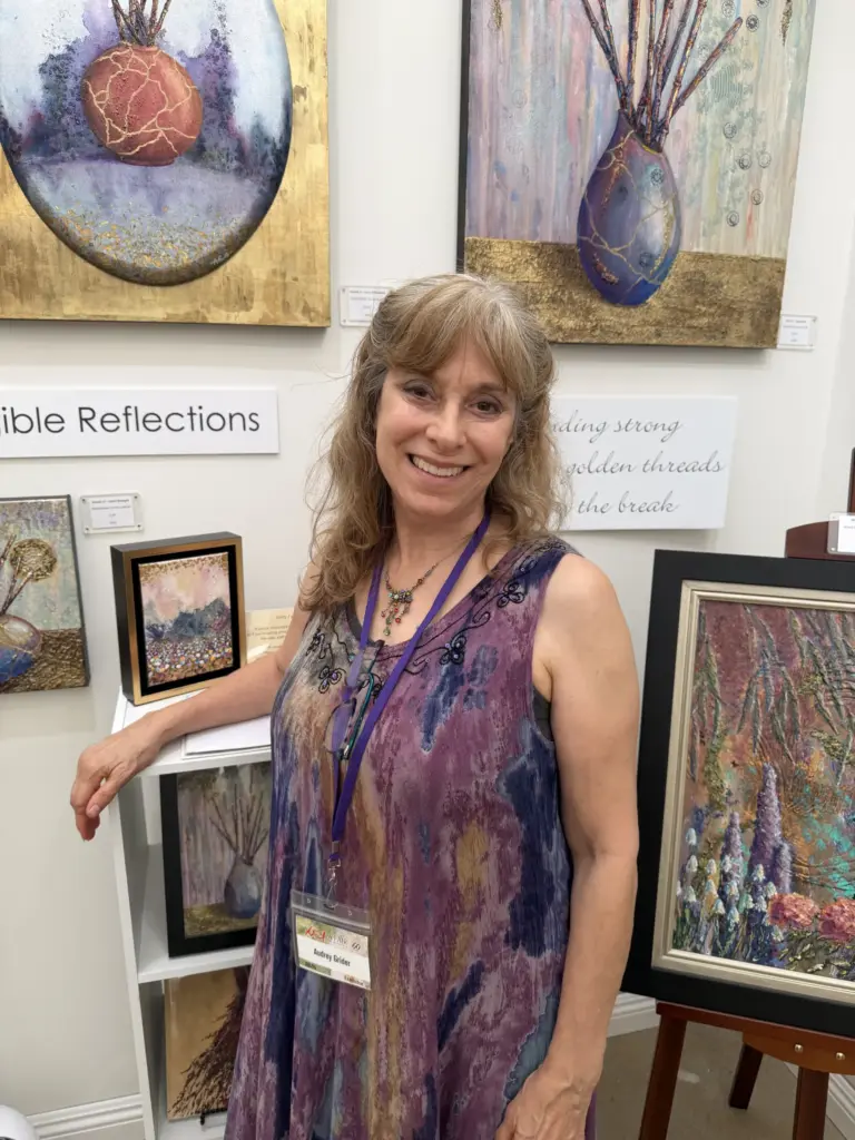 Laguna Woods resident Audrey Grider stands at her booth, themed...