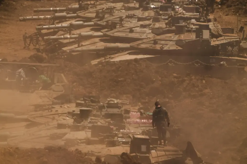 An Israeli soldier works on a tank near the border...