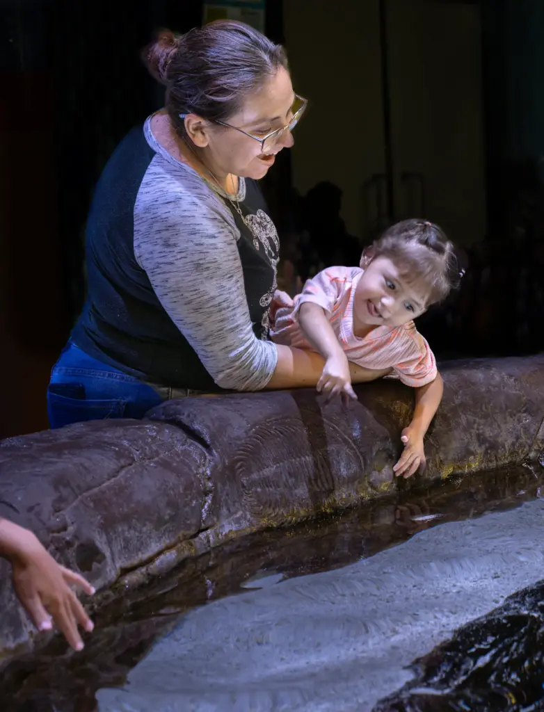 Jesica Munoz helps her 1-year-old daughter Samantha get a better...