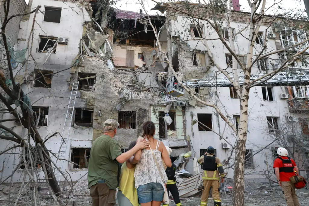 Residents look at their ruined home following a Russian air guided bomb strike.