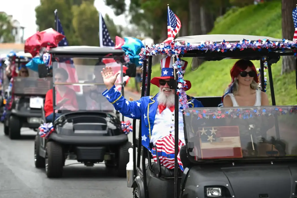 Decorated golf carts ride down Calle Aragon road during the...