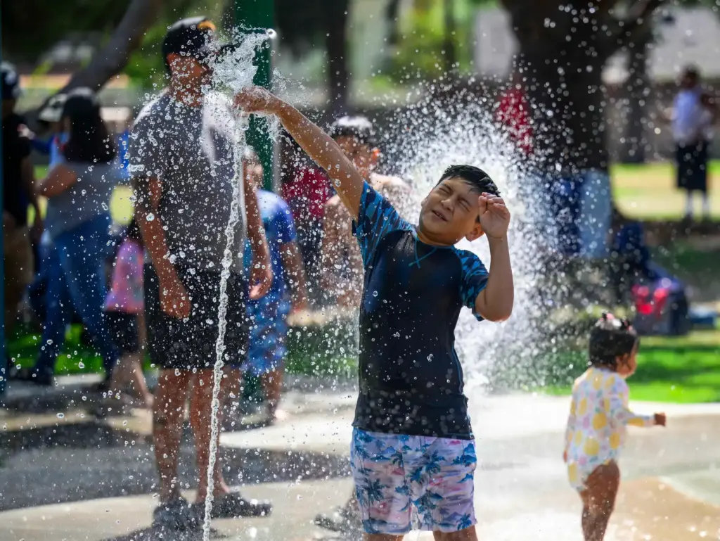 A boy plays with water spouting from the new Splash...