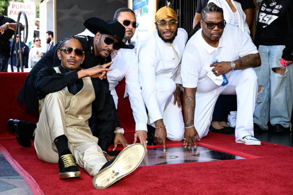 Hip hop group Bone Thugs-N-Harmony pose with their new star...