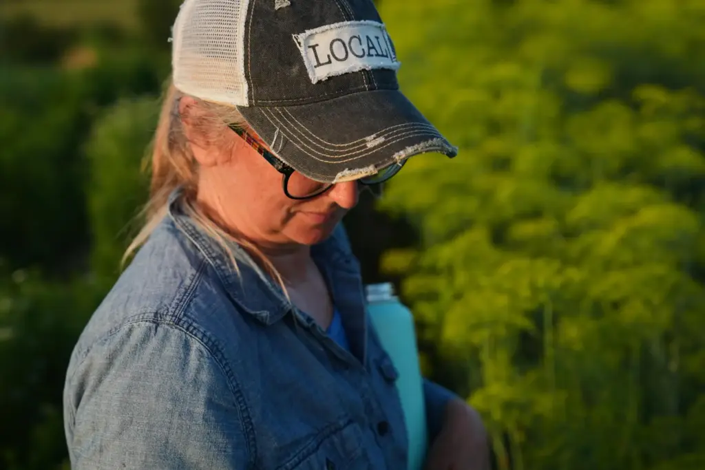 Annie Woods inspects herbs while harvesting.