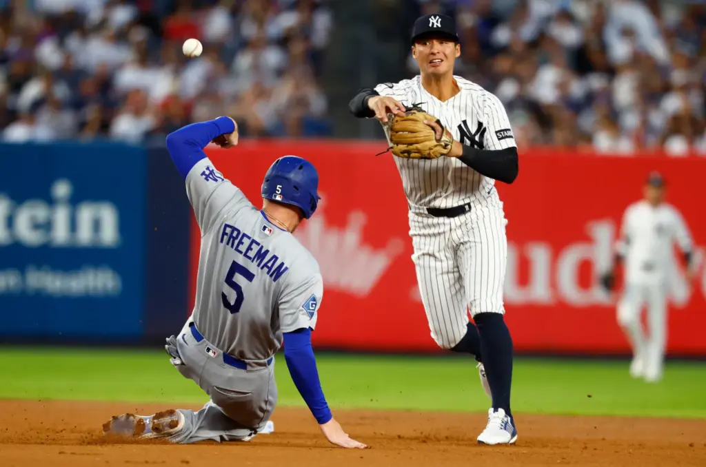 New York Yankees’ shortstop Anthony Volpe, right, throws to first...