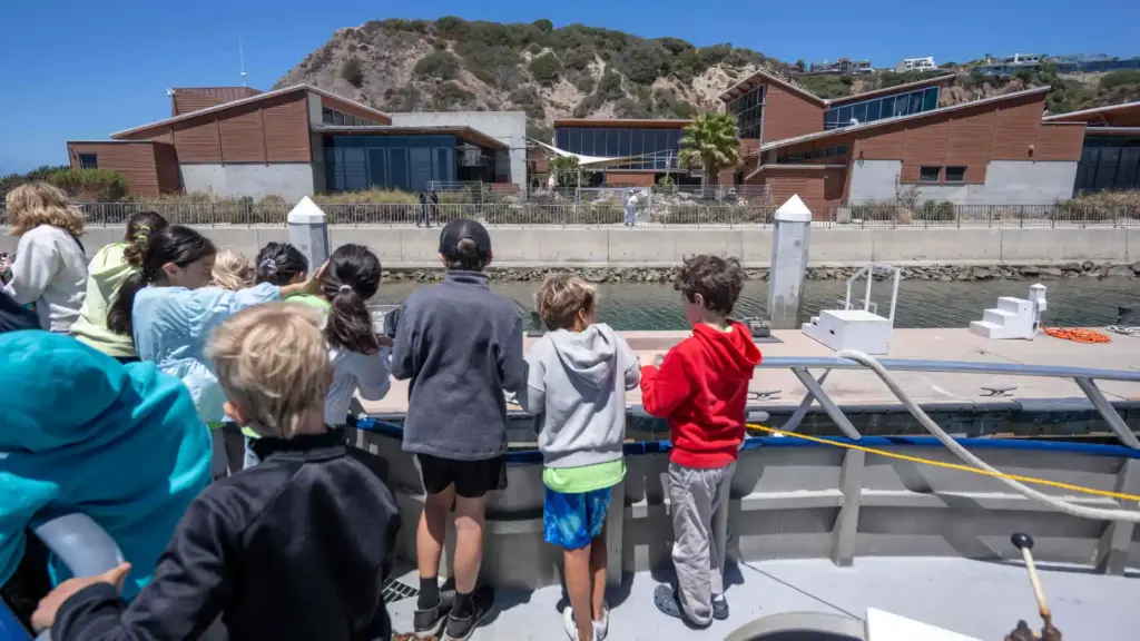 Ocean Institute campers look over the railing of the Research...