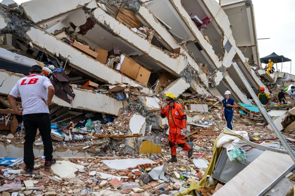 Volunteers and a Mexican rescuer help to find survivors in...