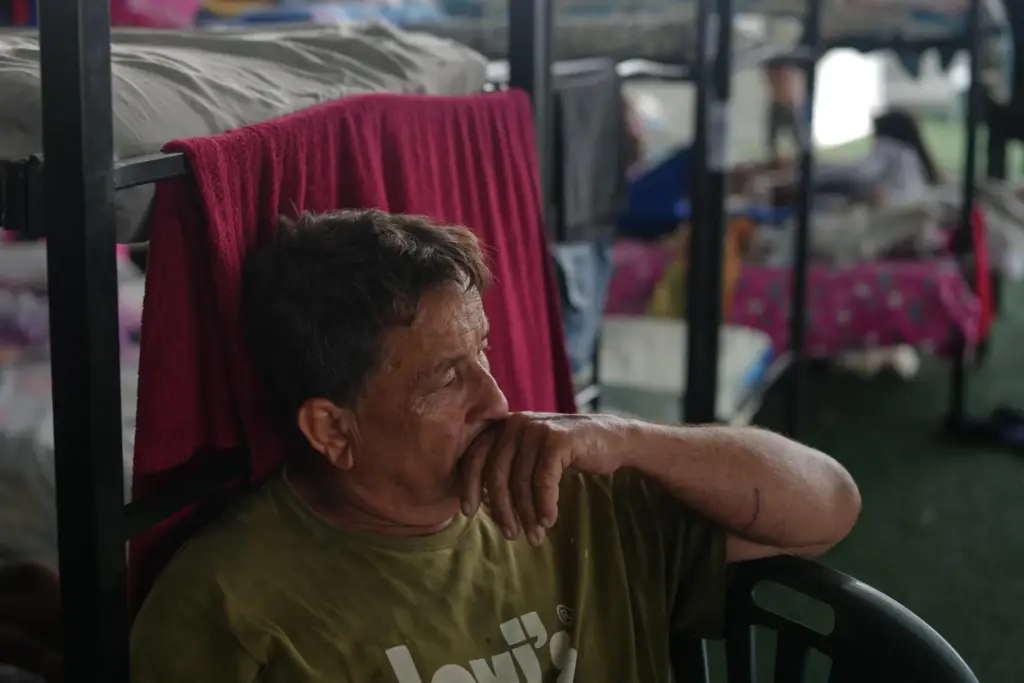 Javier Contreras sits at a sports center sheltering people displaced...