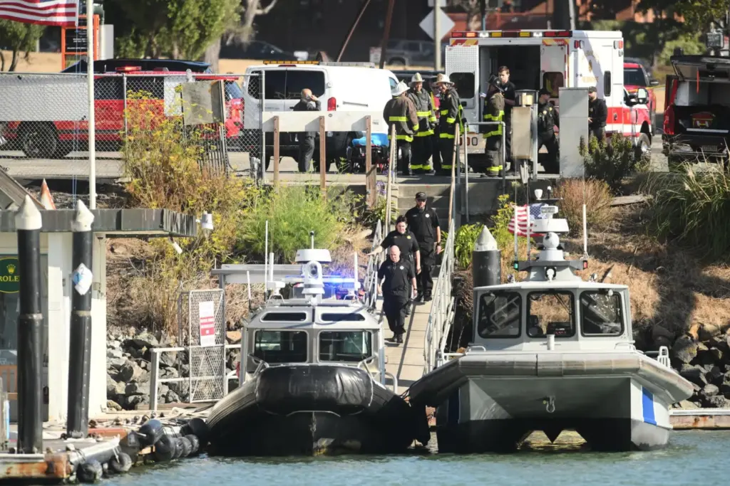 Emergency crews gather at a dock near the site of a pontoon boat fire.