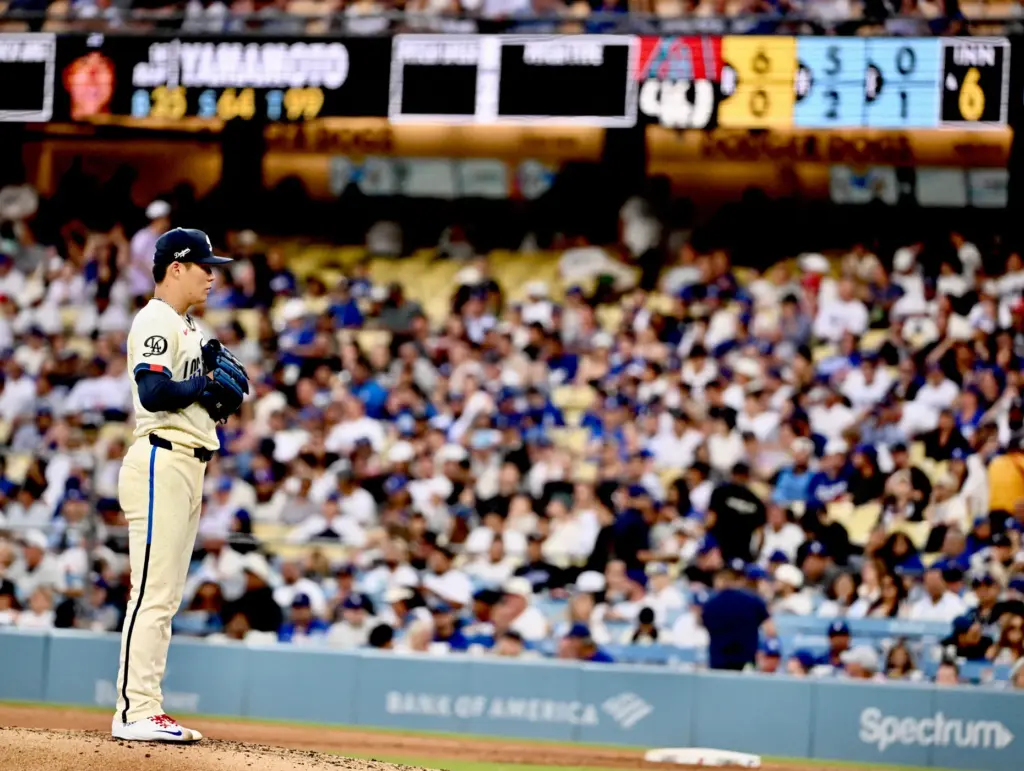 Starting pitcher Yoshinobu Yamamoto of the Dodgers looks on after...