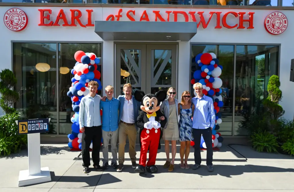 Luke Montagu, 12th Earl of Sandwich, stands with Mickey Mouse...