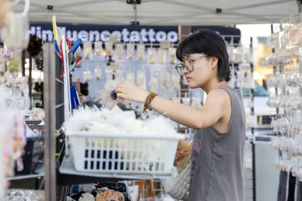 Thanh Tong organizes merchandise at the Toy Outlet stand on...