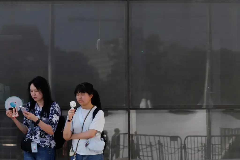 Visitors use fans as as they wait to enter the Washington Monument.