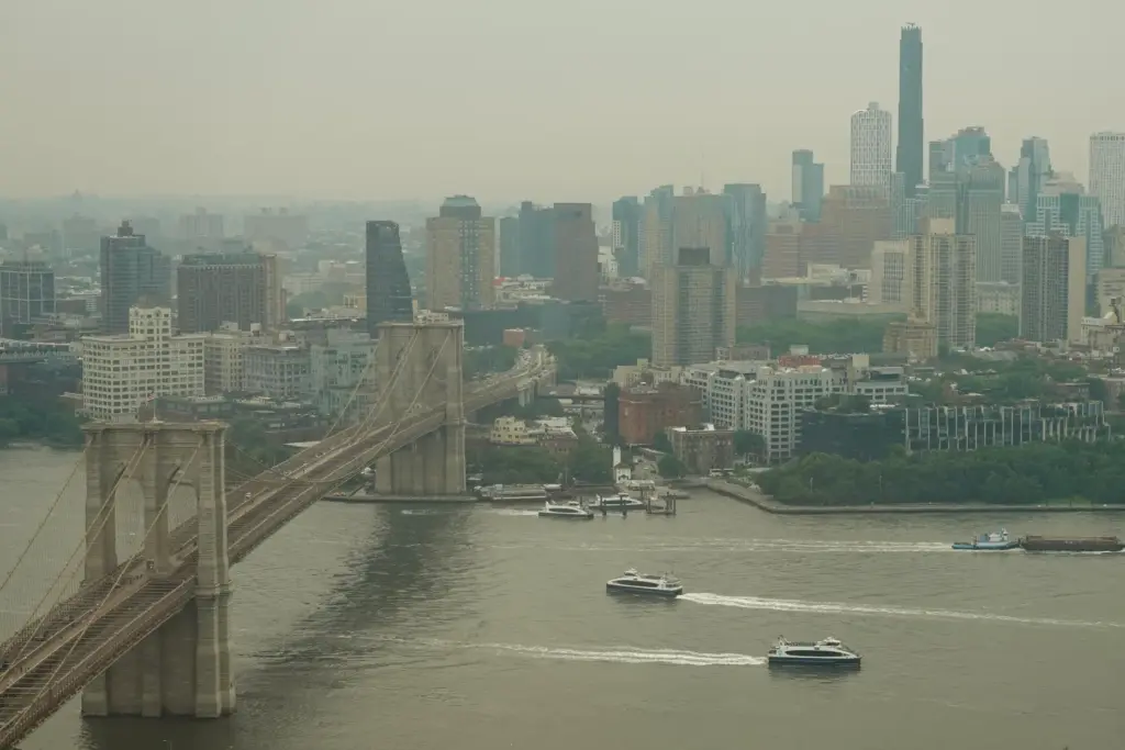 Boats maneuver the East River near the Brooklyn Bridge as...