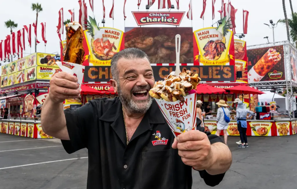 Charlie Boghosian of Chicken Charlieâs greets a fair-goer as he...