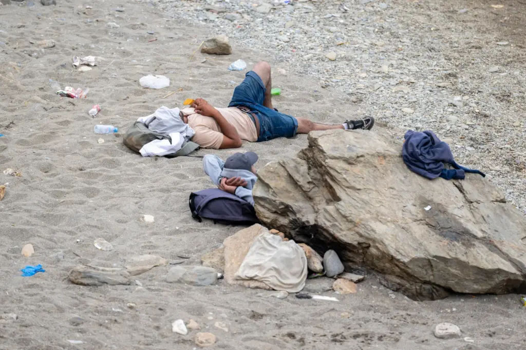 People sleep on a beach.