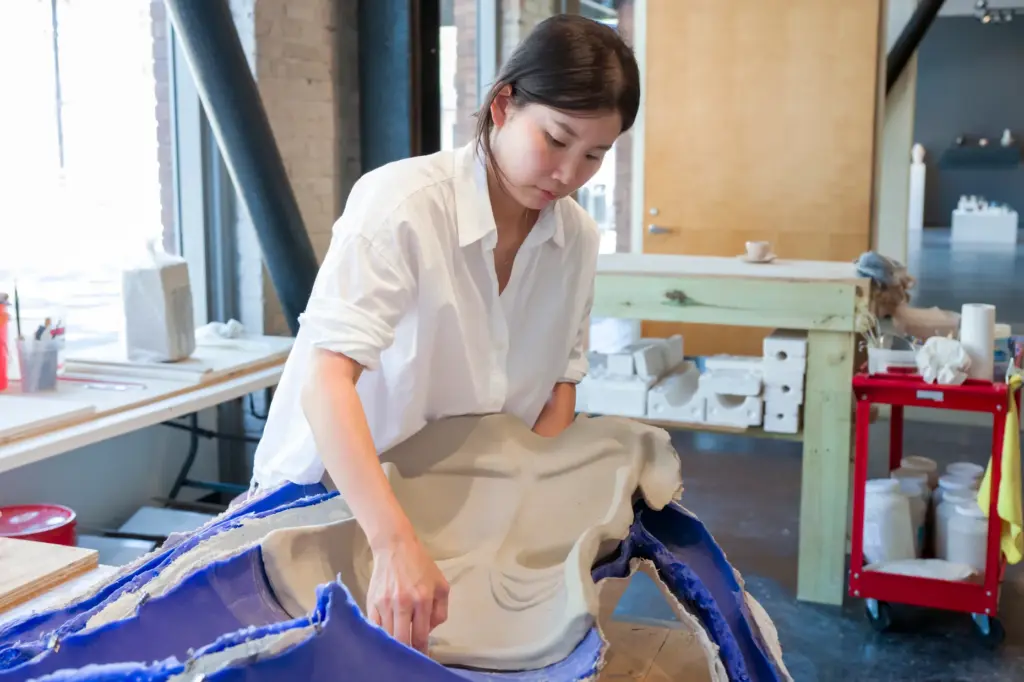 Artist Misty Choi removes a plaster body cast from a...