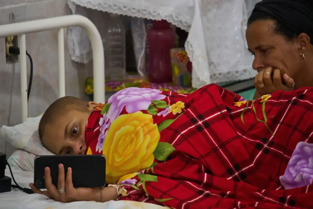 Salet Fernandez, a 17-year-old oncology patient, looks at her phone...