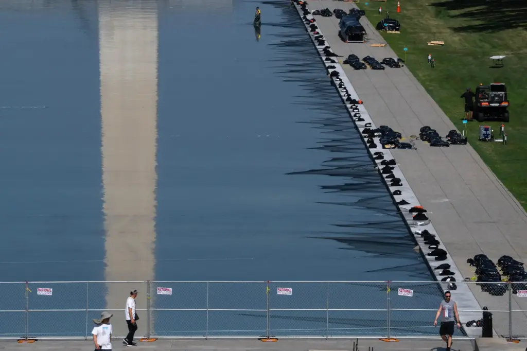 Workers install fireworks along the edge of the Lincoln Memorial...