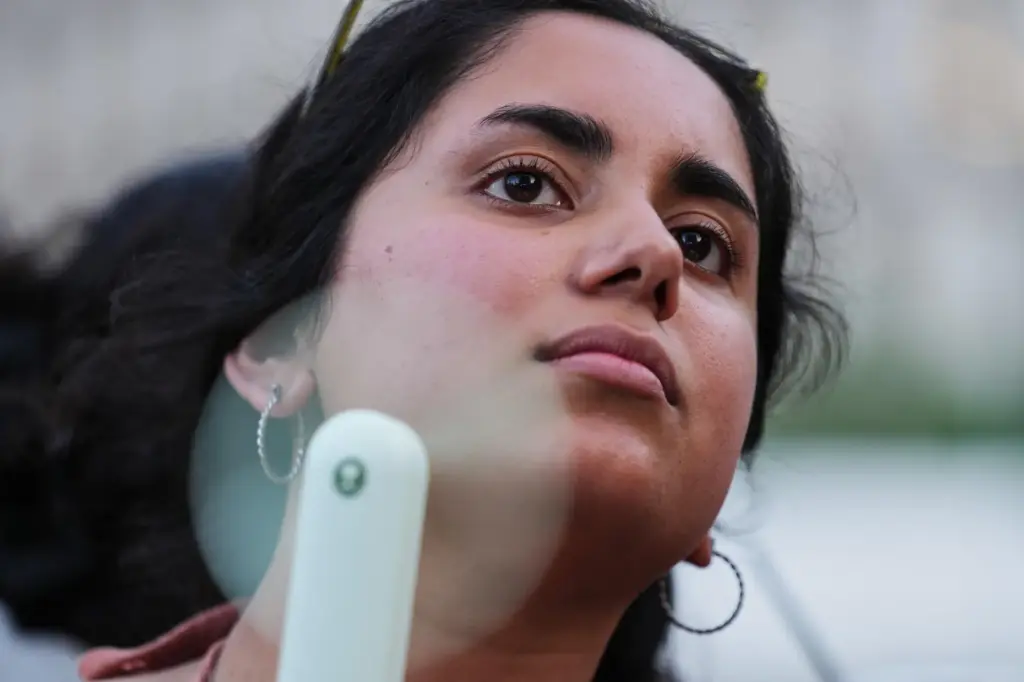 Meghana Jalagam uses a fan to keep cool from the heat during a World Cup game.