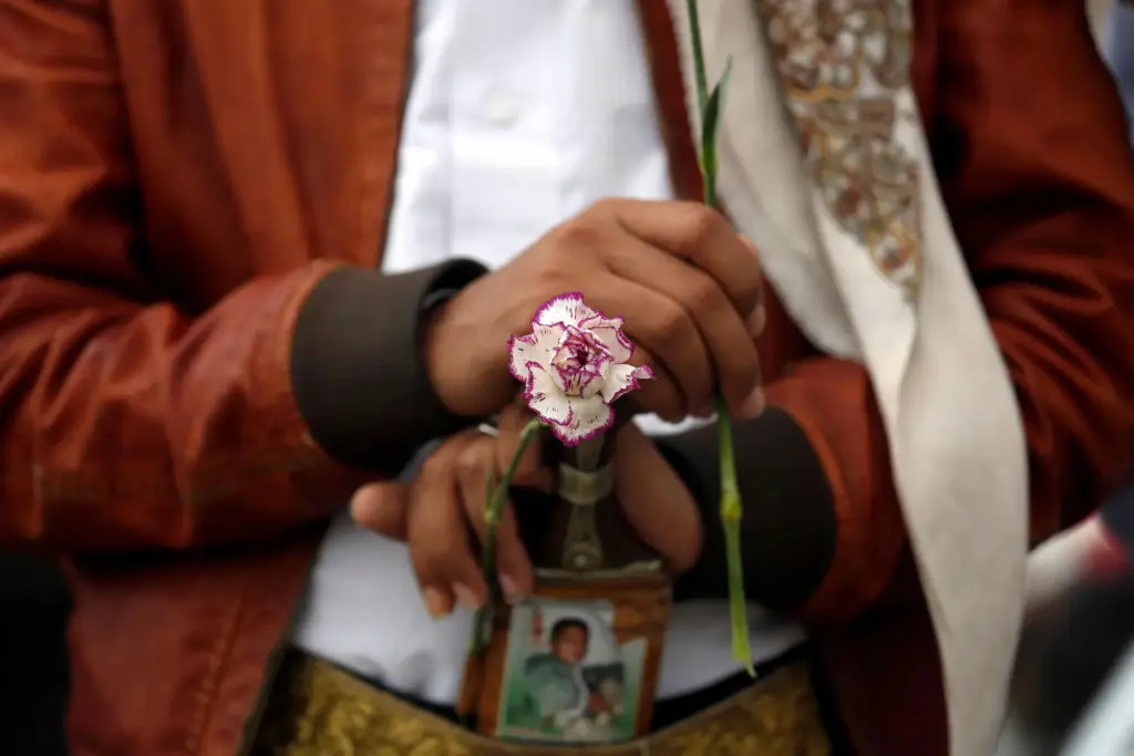 A member of the Baha'i faith holds a flower as he protests.