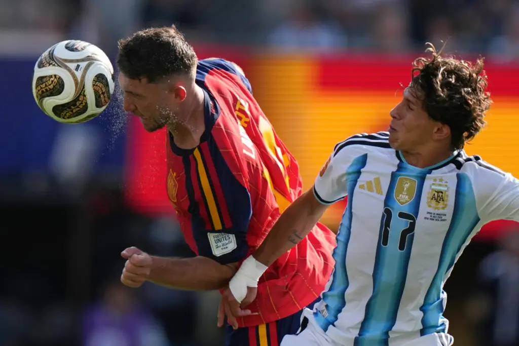 Spain’s Aymeric Laporte (14) heads the ball past Argentina’s Giuliano...