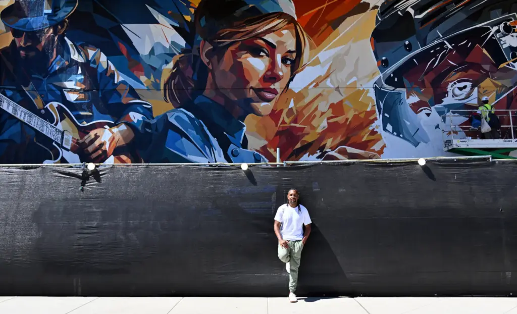 Miami-based artist Brian Peterson next to his mural at OC...