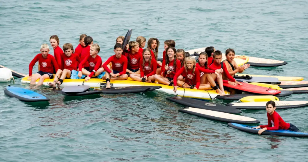 Junior lifeguards encourage their fellow guards as they jump off...