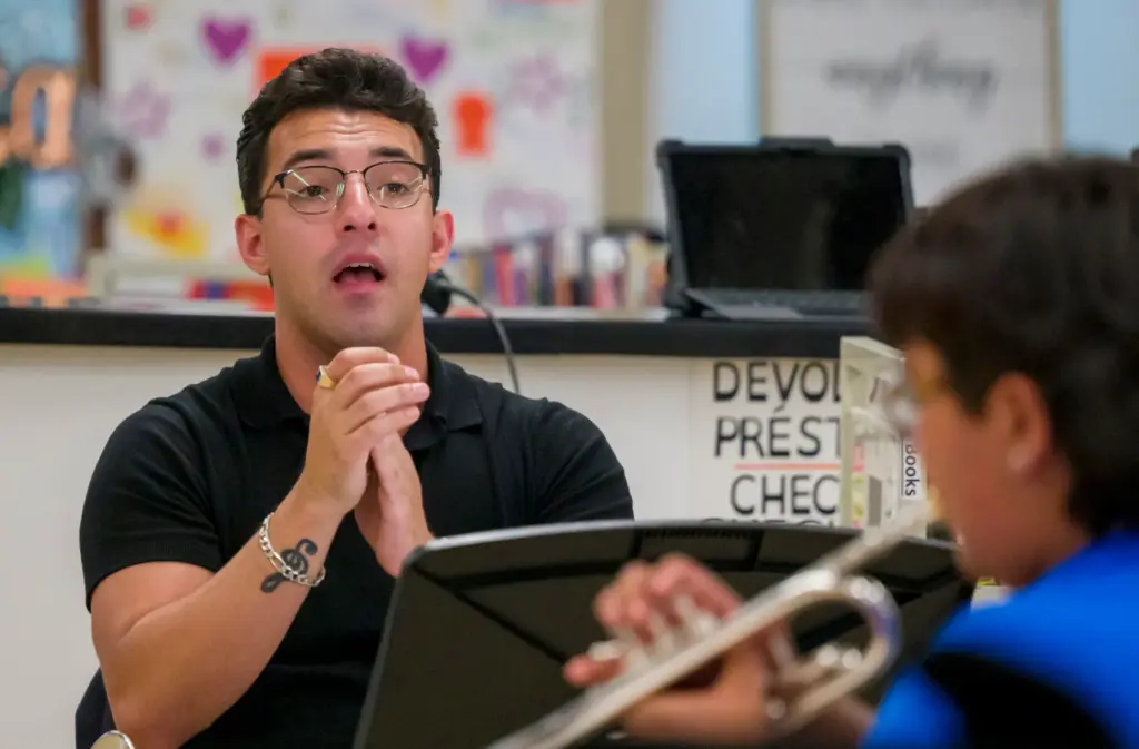 Music instructor Carlos Toledo leads his intermediate trumpet class during...