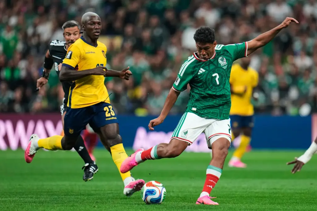 Mexico’s Luis Romo, right, kicks the ball past Ecuador’s Moises...