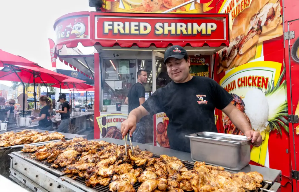 A worker prepares chicken at Chicken Charlieâs at the San...