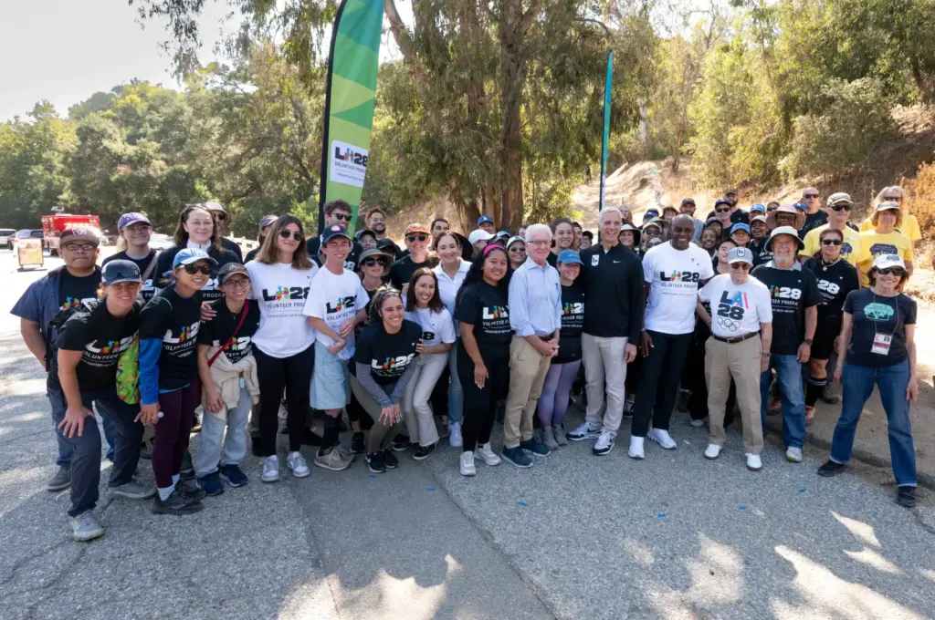 Olympic volunteers pose for a photo during a press event...
