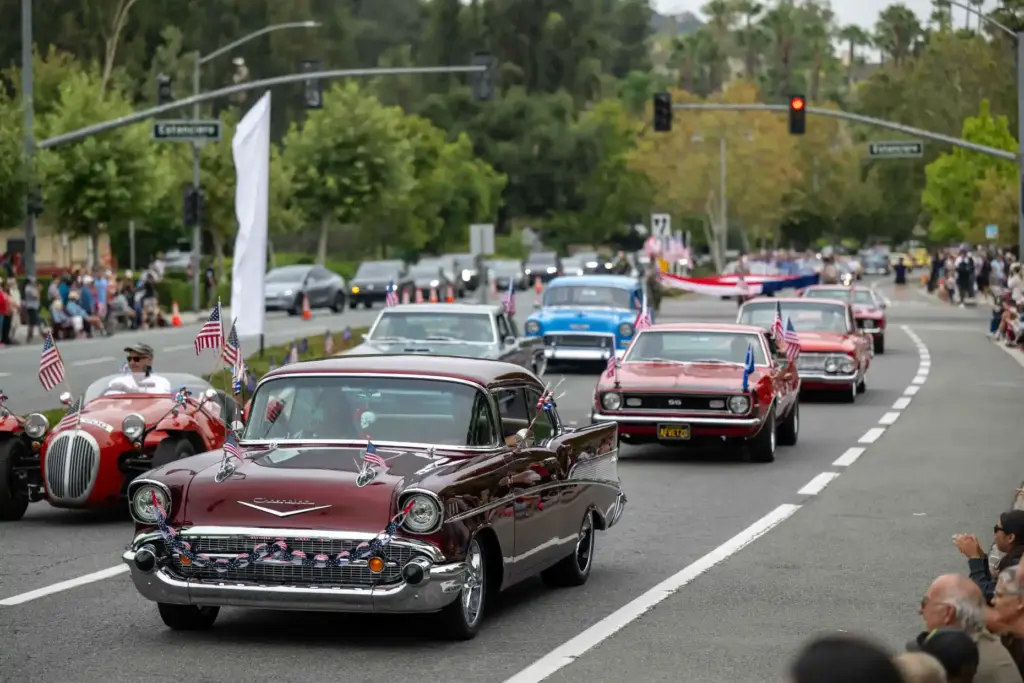 Classic cars drive along Marguerite Parkway during the cityâs America...
