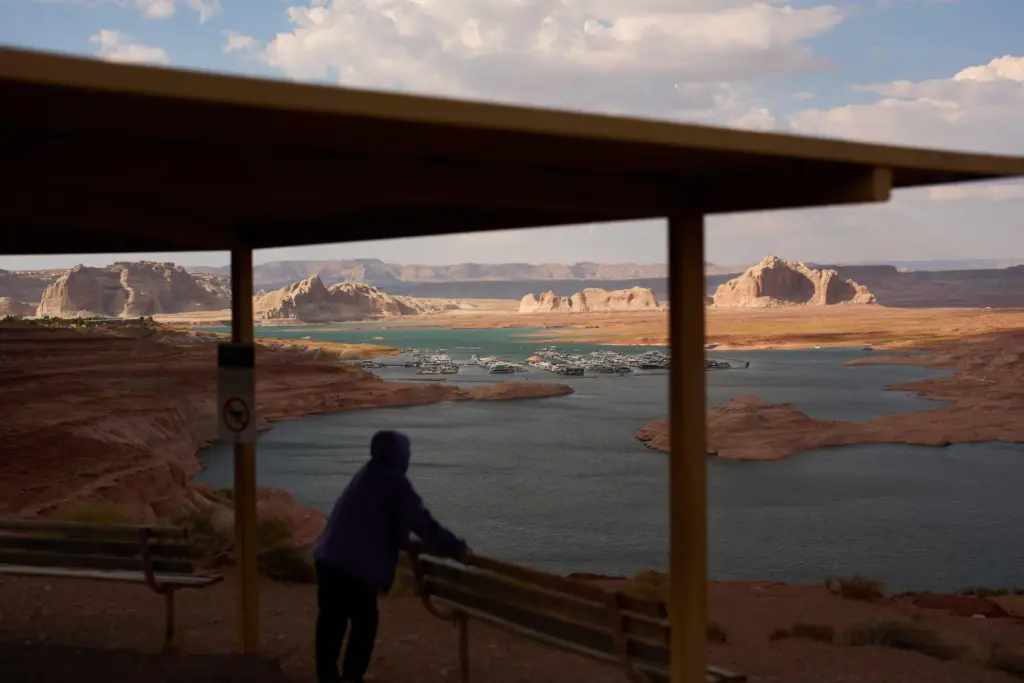 A person stands at an overlook near the Wahweap Marina...