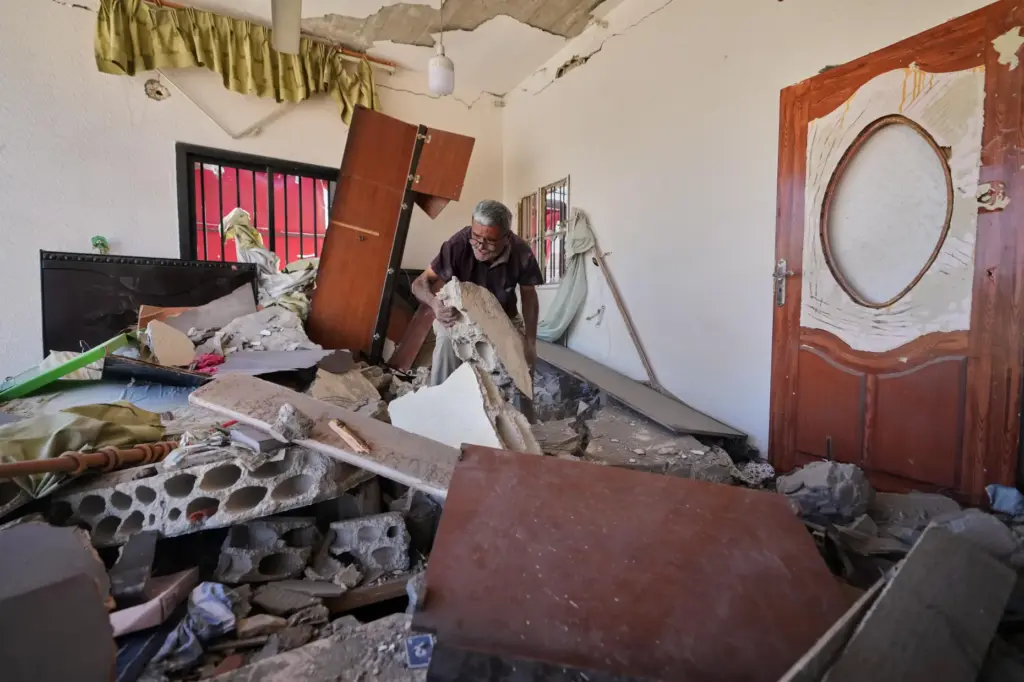 Mohammed Sobeih clears debris inside his home.