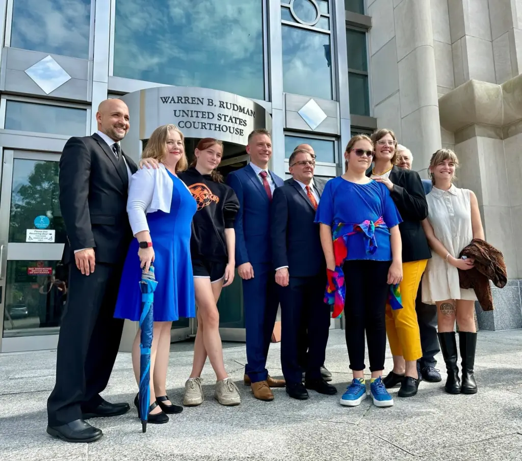 Parker Tirrell and Iris Turmelle pose with their families and attorneys.