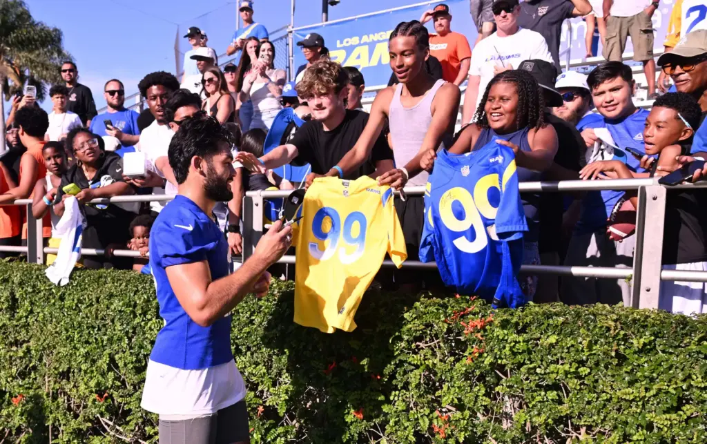 Rams wide receiver Puka Nacua signs autograhs the first day...