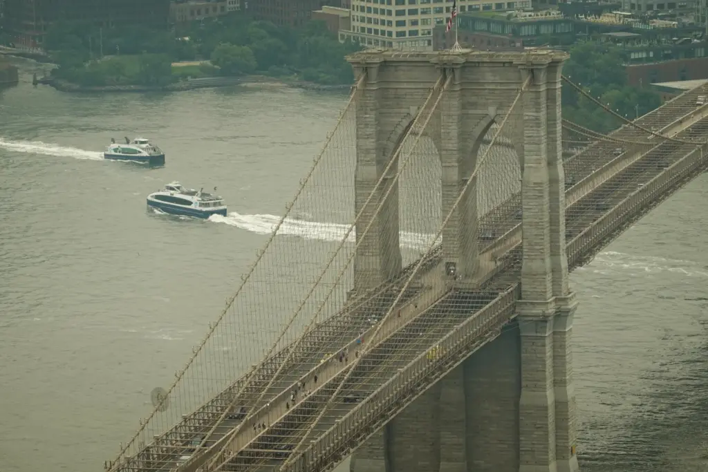 Boats maneuver the East River near the Brooklyn Bridge as...