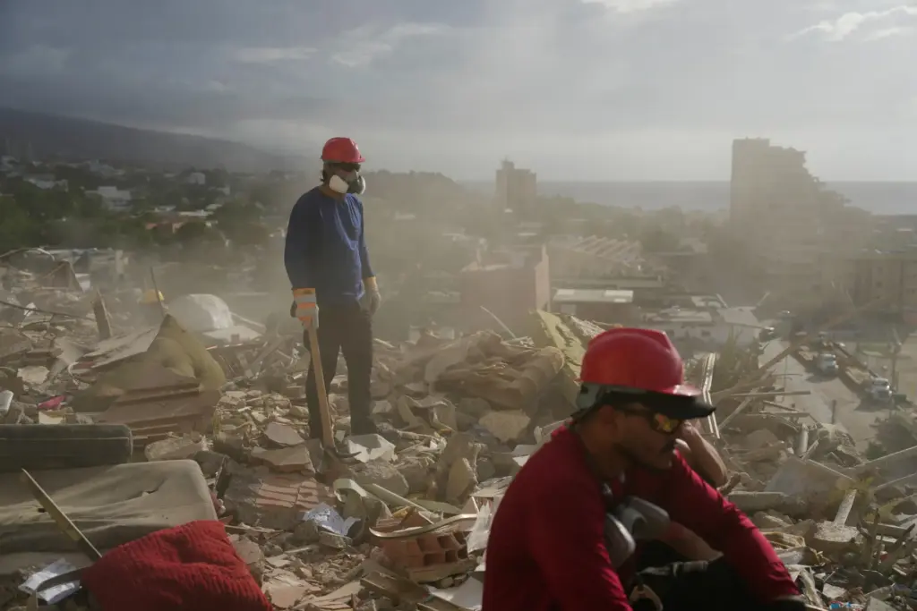 FILE – Rescue workers and volunteers search through the rubble...
