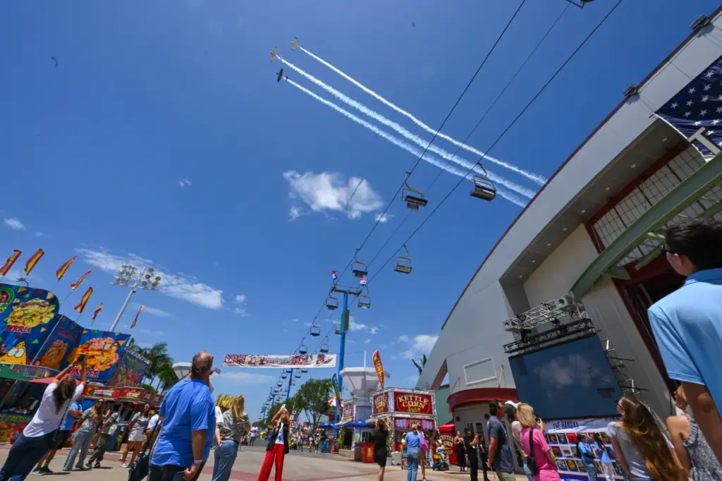 Three 1950-era Beechcraft T-34s fly over opening day at the...