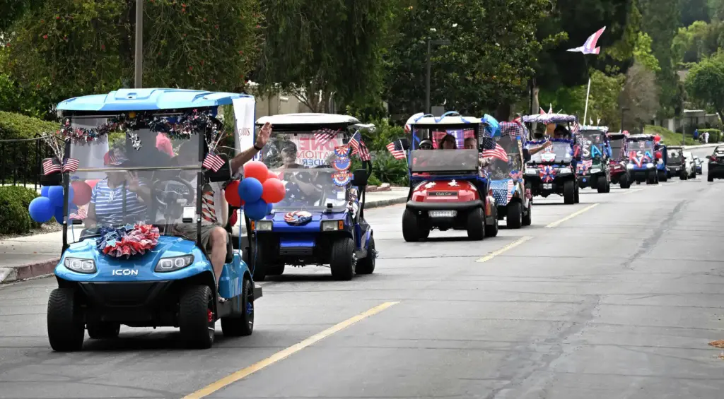 Decorated golf carts ride down Calle Aragon road during the...